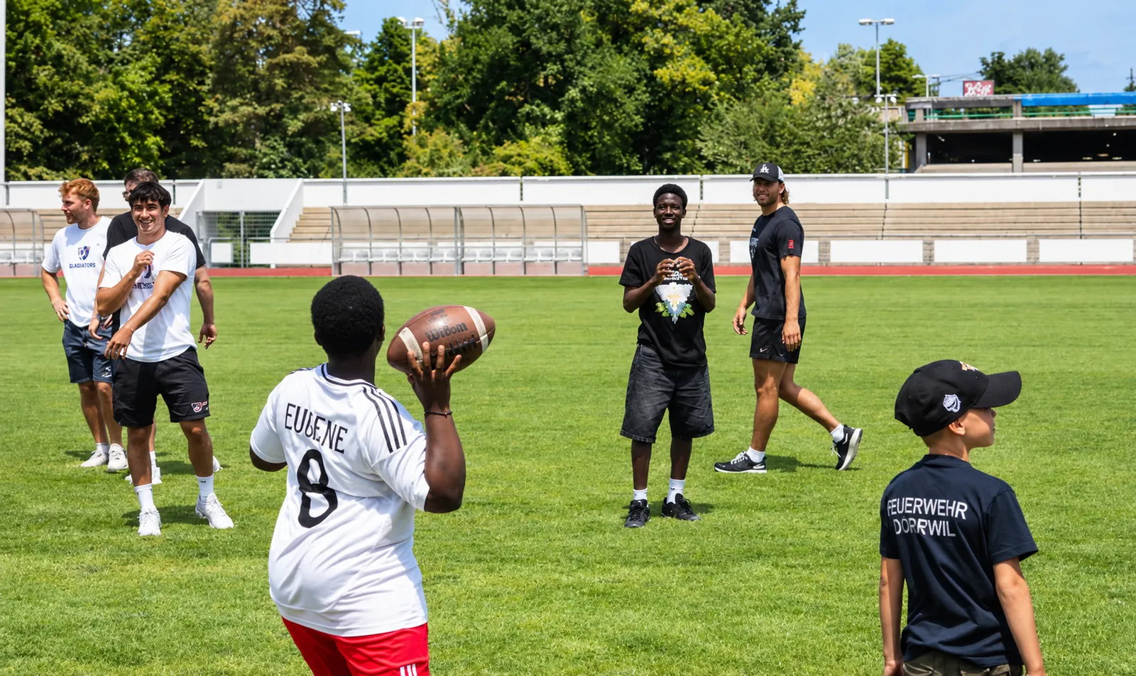 Kids and players throwing a football on the field